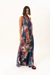 Vestido largo de corte recto y escote strapless, con estampado estilo batik en tonos azul, naranja y bordó. Incluye una bufanda larga integrada al diseño que cae desde el cuello.