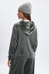 Campera deportiva con cierre frontal, confeccionada en tela de plush con acabado brillante. Presenta mangas largas tipo raglán, capucha con cordones ajustables y puños elásticos.