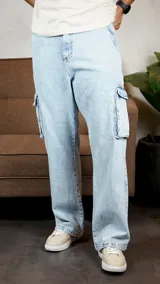 Pantalón cargo de denim en lavado claro con efecto desgastado, corte holgado y bolsillos laterales con solapa.