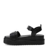 Sandalias de plataforma baja Miss Carol modelo Taze, color negro, con diseño de tiras anchas, hebillas metálicas decorativas y tira ajustable en el talón.