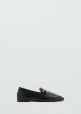 Mocasines planos de mujer confeccionados en piel bovina color negro, con punta redonda y detalle metálico dorado en el empeine.