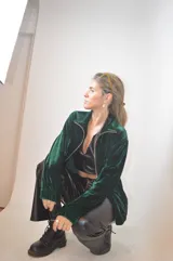 Campera verde inglés de terciopelo con cierre dorado y cuello alto.