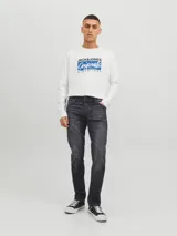 Jean de corte slim con tiro bajo, confeccionado en denim de color negro con efecto lavado. Presenta diseño clásico de cinco bolsillos y cierre frontal con botón.