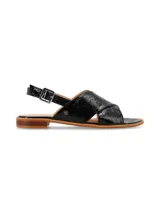 Sandalia de cuero charol negro con tiras anchas cruzadas en el empeine y tira trasera con hebilla metálica ajustable. Cuenta con suela plana y taco bajo de madera.