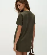 Vestido corto de corte recto confeccionado en gamuza sintética color marrón. Presenta cuello redondo, mangas cortas y un acabado liso. Incluye un cinturón fino del mismo tono con hebilla metálica.