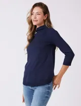 Buzo azul marino de tejido acanalado, con cuello alto tipo mock neck y mangas tres cuartos.