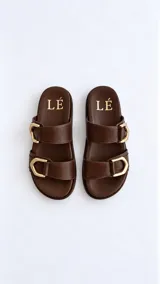 Sandalias de horma anatómica color marrón, confeccionadas en cuero texturado, con dos tiras anchas ajustables mediante hebillas metálicas doradas.