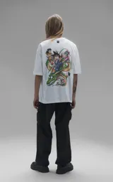 Remera blanca de corte oversize con cuello redondo y manga corta. Presenta una estampa central a todo color con personajes de Dragon Ball montados sobre el dragón Shenlong.