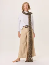 Bufanda larga de lana con diseño tejido en patrón geométrico de colores negro y tostado, con terminación de flecos calados.