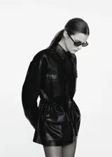 Parka oversize de piel ovino en color negro, con cuello de solapa, manga larga, bolsillos delanteros con solapa y cintura ajustable.
