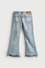 Jeans flare fit de tiro medio, confeccionados en denim de algodón color azul con efecto deslavado. Diseño ajustado en la parte superior y abierto en campana desde la rodilla, con cinco bolsillos y cierre frontal con cremallera y botón.