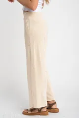 Pantalón de corte recto y tiro medio, confeccionado en tejido de algodón con textura acanalada. Presenta cintura elástica, bolsillos laterales y un calce holgado y cómodo.