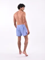 Short de baño blanco con estampado de hojas en tonos azules y rosados, cintura elástica con cordón ajustable.