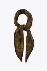 Bandana de forma alargada confeccionada en viscosa con acabado satinado. Presenta un diseño estampado que combina un patrón geométrico de rombos pequeños con bordes decorados con motivos ornamentales y paisley en tonos marrones y dorados.