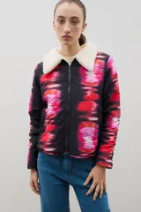 Campera con cierre frontal, cuello de sherpa en color crema y elástico ajustable en la cintura. Presenta un diseño estampado con efecto visual difuminado en tonos negros, rojos y rosados.