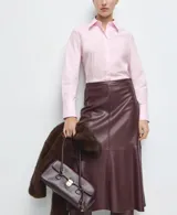 Camisa entallada de popelín de algodón en color rosado, con cuello camisero, manga larga y cierre frontal con botones ocultos bajo tapeta.