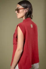 Chaleco de lana color crema con diseño de flor bordada en relieve en el frente, cuello redondo y aberturas laterales en el ruedo.