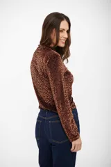 Top de manga larga con cuello alto, confeccionado en tejido aterciopelado con estampado animal print de leopardo en tonos marrones.