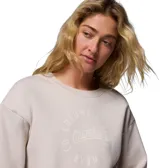 Buzo de cuello redondo color gris claro, confeccionado en mezcla de algodón, con diseño de hombros caídos, puños y dobladillo acanalados. Presenta un estampado circular frontal con la inscripción "Columbia Sportswear" en tonos claros.