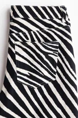 Pantalón de cinco bolsillos en sarga de algodón, de cintura estándar y diseño barrel con estampado de cebra en blanco y negro.