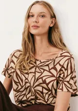 Blusa de manga corta con cuello redondo y estampado de cuadrícula blanca sobre fondo color tostado.