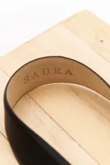 Cinturón negro de cuero sintético con hebilla plateada de estilo western y apliques metálicos plateados.