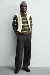 Pantalón de corte baggy fit confeccionado en tejido de algodón con textura y efecto lavado. Presenta diseño de cinco bolsillos, cierre frontal con cremallera y botón.