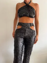 Top negro con lentejuelas, corte halter y espalda descubierta.