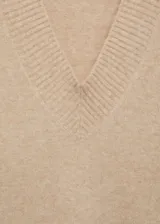 Jersey de punto medio con cuello en pico y terminaciones de canalé en puños y bajo. Presenta un diseño recto y oversize de manga larga.