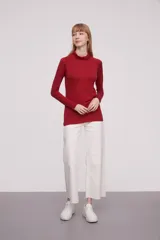 Polera de viscosa color rojo, de corte ajustado al cuerpo, con cuello alto y mangas largas.