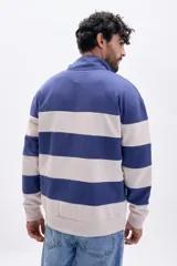 Buzo deportivo de hombre con medio cierre, cuello alto y bloques de color azul y beige en rayas horizontales.