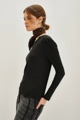 Remera de viscosa en color beige, de manga larga con detalle de frunces en los hombros y un pronunciado escote en la espalda con tira horizontal.