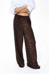 Pantalón de punto de corte holgado con piernas amplias y tiro alto, cintura elástica con cordón de ajuste y estampado animal print de leopardo.
