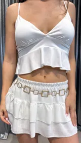 Cinturón tipo caderín con cadena dorada de eslabones cuadrados.