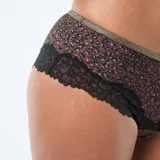 Shorty de microfibra con estampado animal print, detalle de encaje negro en los bordes y banda elástica superior en tono dorado.