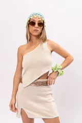 Minifalda tejida color crudo con pespuntes celestes y tajo lateral.