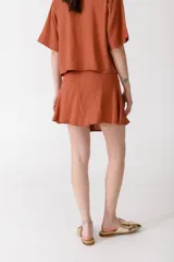 Minifalda roja de lino con botones de madera en el frente.