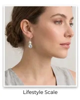 Aros colgantes de plata 925 con diseño articulado que presenta una perla esférica en la parte superior y una circonia redonda facetada de color celeste en el extremo inferior.