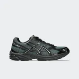 Championes de running Asics modelo GEL-1130, color verde oscuro y negro, con detalles metalizados plateados. Incorporan tecnología GEL en el talón, confeccionados con malla transpirable y refuerzos sintéticos.