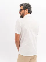 Camisa de manga corta de algodón en color beige, con cuello camisero y cierre frontal de botones, con diseño estampado sutil.