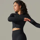 Campera negra de tejido de punto acanalado, corte cropped y cierre frontal con cremallera.