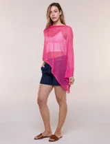 Poncho liviano fucsia confeccionado en tejido de punto fino calado, con efecto de semitransparencia y caída vaporosa, escote bote y diseño asimétrico.