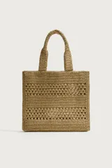 Bolso tipo shopper color beige con acabado trenzado y diseño de bandas con calados. Cuenta con compartimento principal sin cierre y dos asas de mano.