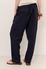 Pantalon de lino color verde militar, de corte recto y holgado, con cintura elastizada y cordón ajustable.