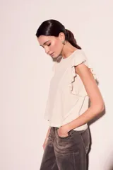 Remera color crema de corte recto con mangas cortas con volados.