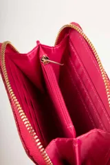 Billetera dorada con glitter, cierre perimetral con cremallera y dije de estrella. Interior con seis ranuras para tarjetas y monedero central con cremallera.