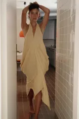 Vestido mini de mezcla de lino en color beige, con cuello halter, escote en V y diseño drapeado fluido.