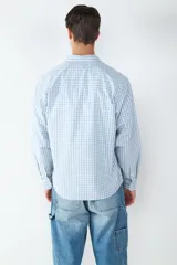 Camisa celeste y blanca a cuadros, de algodón, corte oversize y cuello clásico.