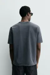 Camiseta regular fit de color beige, confeccionada en tejido de algodón compacto, con cuello redondo y manga corta.