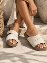 Sandalias planas color marrón con tiras cruzadas y suela moldeada.